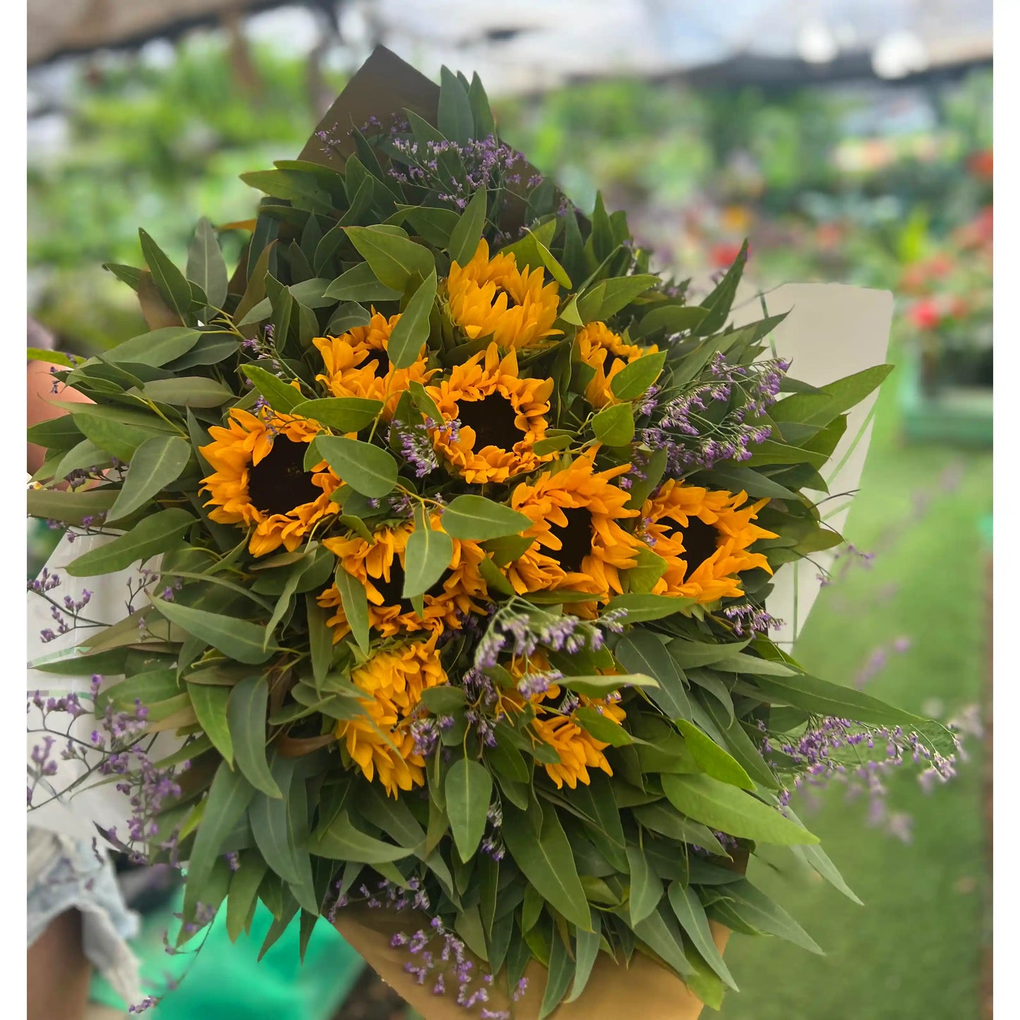 Bouquet of sunflowers and greenery in a garden setting