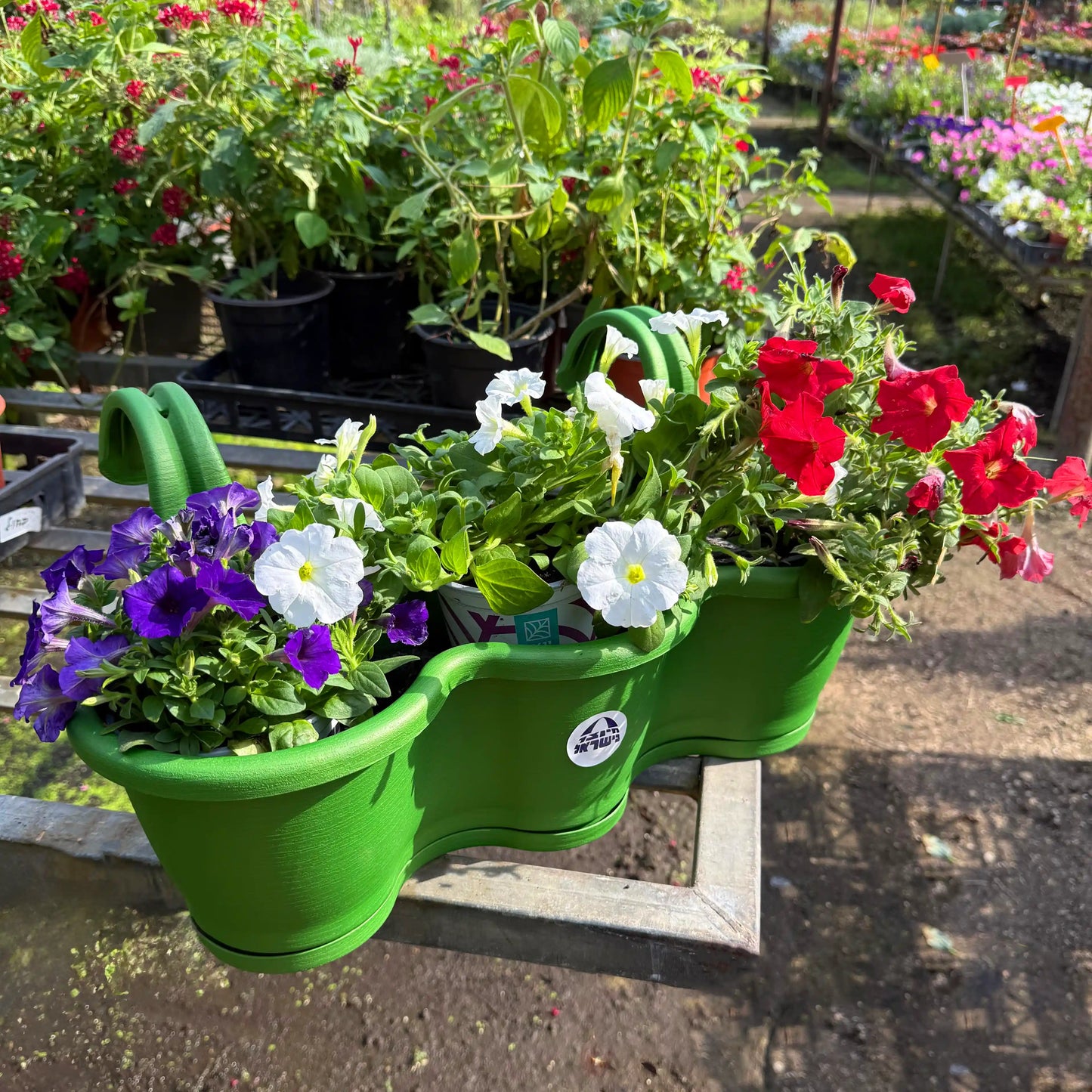 Green hanging planter with flowers in a garden setting