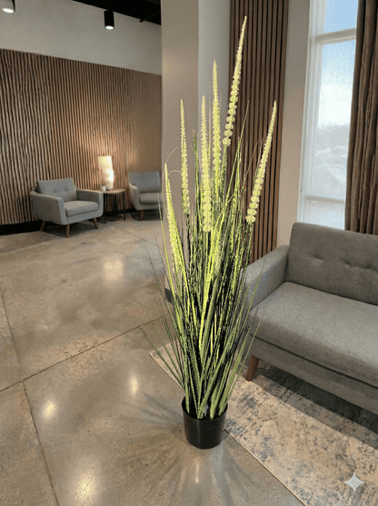 Decorative indoor artifical  plant in a pot on a polished floor with a modern interior setting.