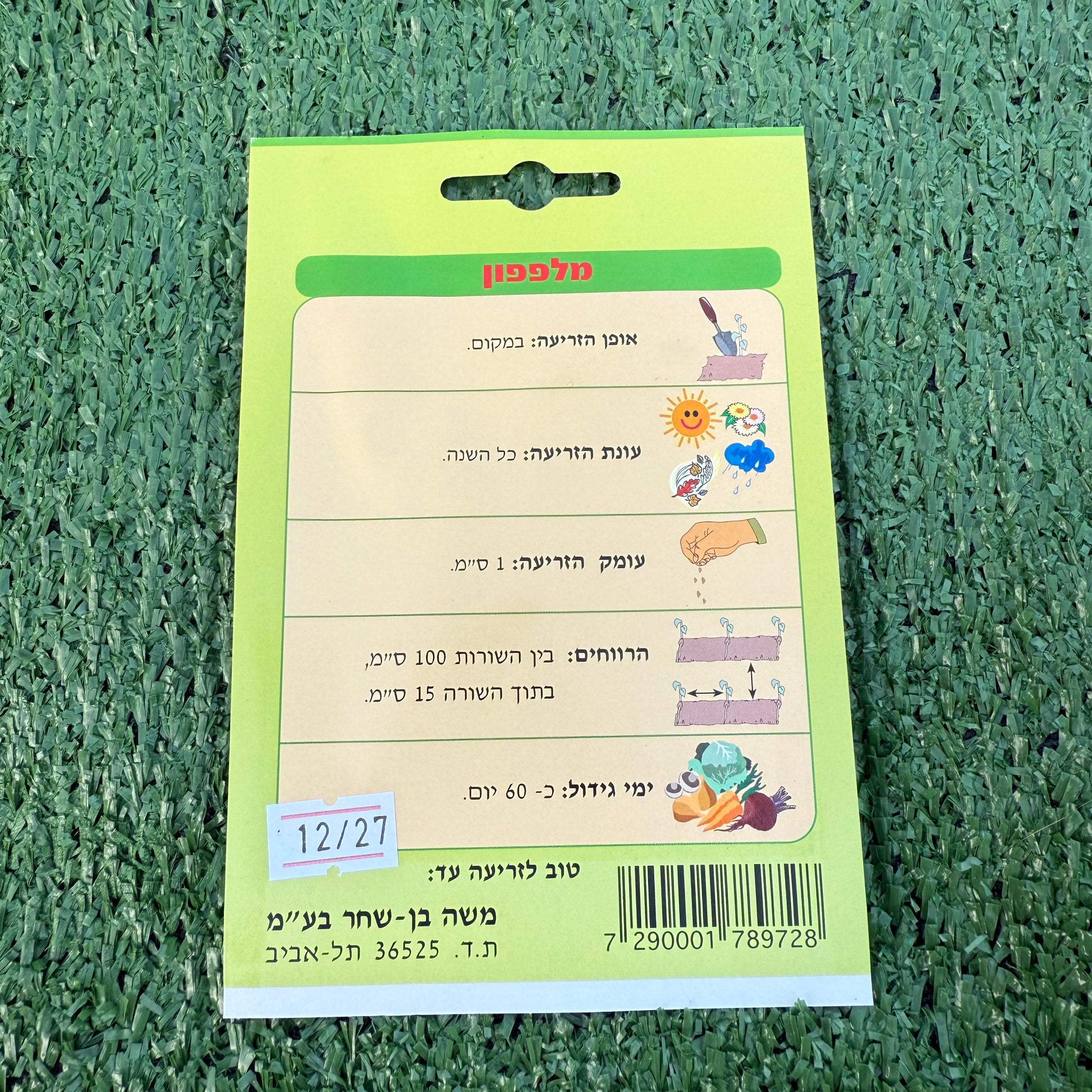 ההוראות מאחורה שבחפיסת זרעי מלפפון ברקע של דשא סינטטי ירוק