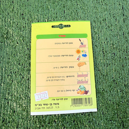 הוראות שימוש של חפיסת זרעי שמיר ברקע של דשא סינטטי ירוק