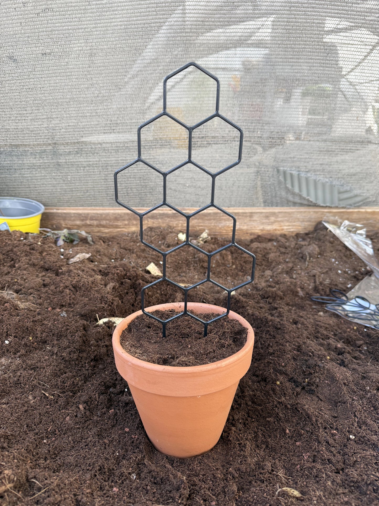 גדר פלסטיק שחורה למטפסים בדוגמת כוורת, 30×13 ס״מ, בהדגמת נעיצה בעציץ – דקו גרדן
