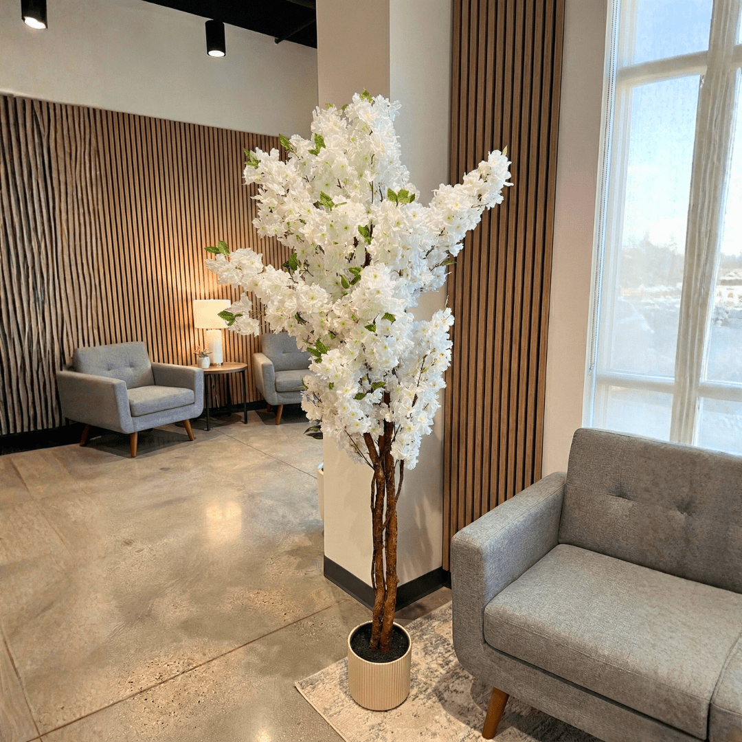 Modern interior with gray sofa, armchairs, and a large white floral arrangement.